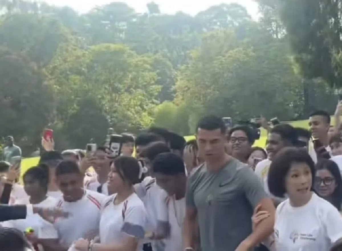 罗纳尔多（右二）6月2日到访新加坡植物园出席活动时，被网民拍到他不经意流露出不悦的神情。如果要他来新加坡踢球，不知道他又会有什么表情呢？（视频截图）