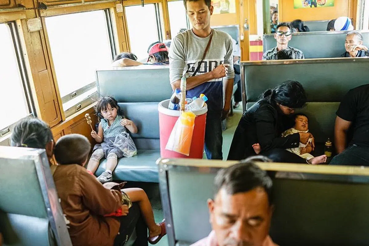  在泰国坐火车是一种享受，这80公里的路程只需要8泰铢(0.34新元)。可以看到小贩们沿街叫卖，孩子们和家人一起休息，小Chow拿着一串肉丸子“引领”她的旅程。 