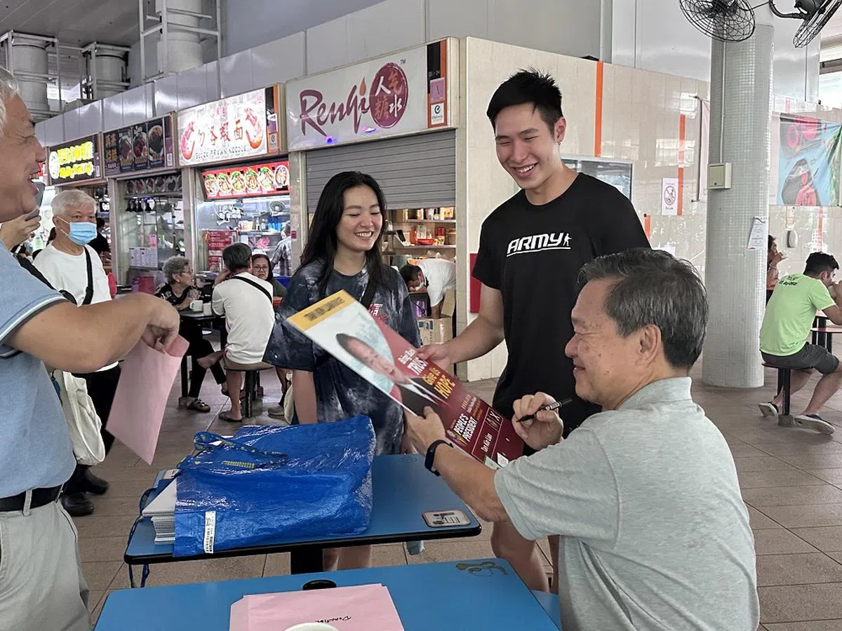 陈钦亮在总统选举结束后的周末，于勿洛巴士转换站的熟食中心售卖附上亲笔签名的竞选海报和传单。（新明日报）