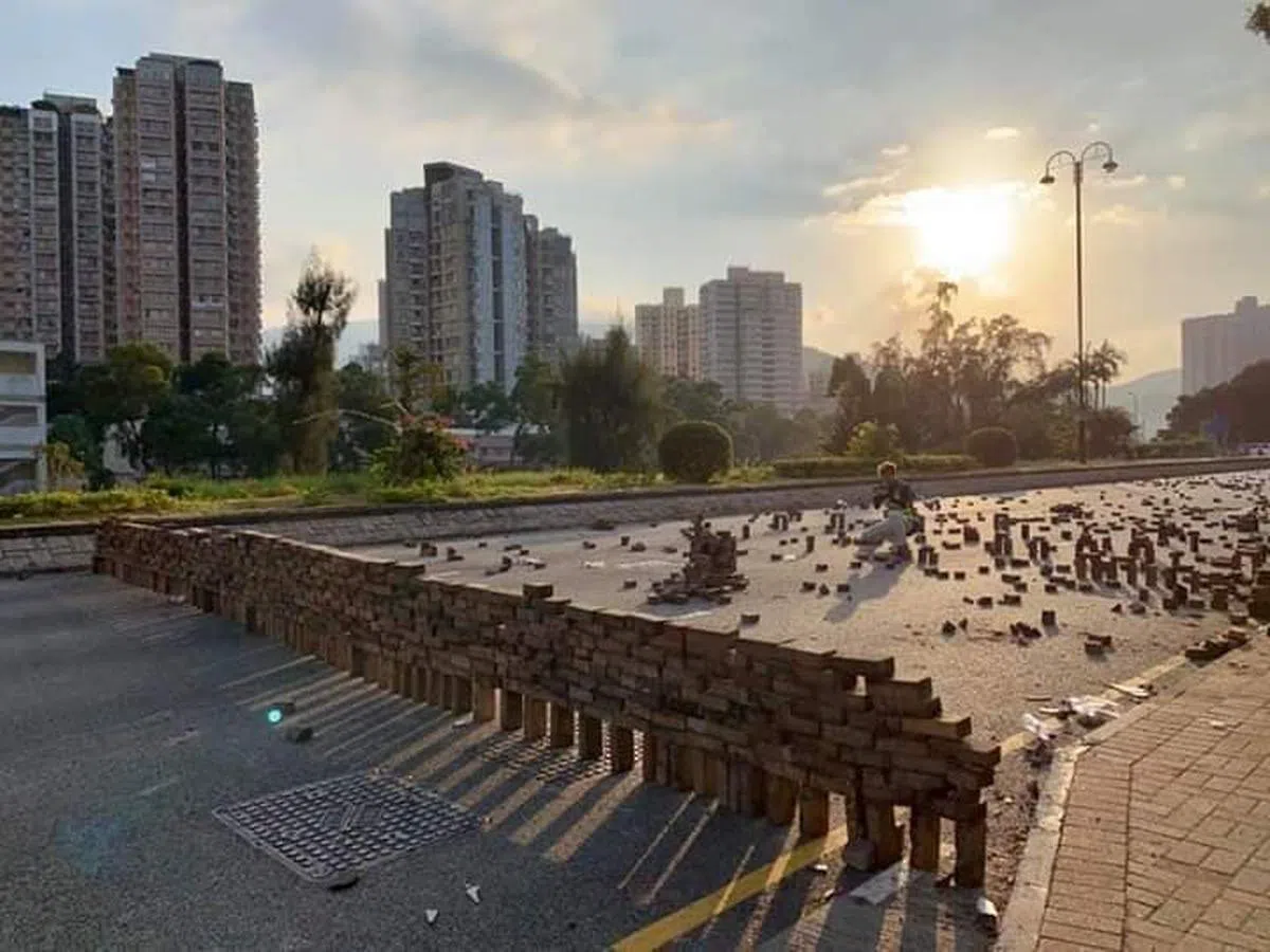  化腐朽为神奇？示威者用无数个砖块在路上建起一道砖块墙，犹如现实版俄罗斯方块游戏，夕阳下焕发出一种诡异的美。（我爱旅行面簿） 