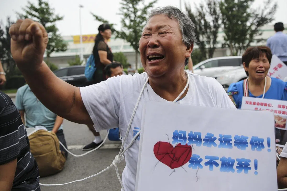  2015年8月7日，马航在北京举行第五次家属见面会，数十名MH370家属聚集在办公楼前，情绪激动。（中新社） 