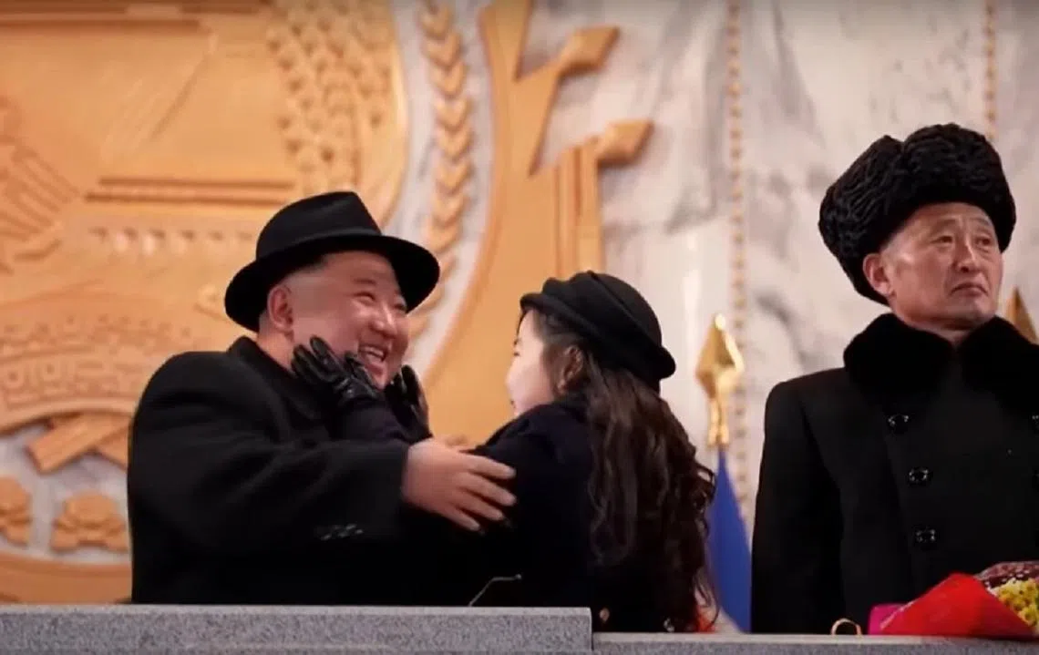 金正恩和女儿金珠爱（中）在朝鲜人民军建军75周年阅兵式上温馨的一幕。（视频截图）