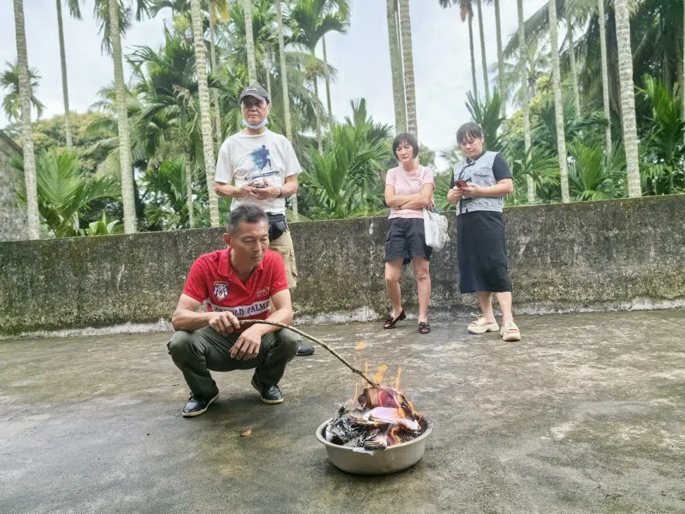 林善华烧金纸给黄氏祖先们。（黄良丰提供）