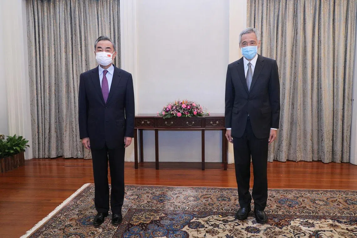 我国总理李显龙（右）今早在总统府会见来访的中国国务委员兼外长王毅。（通讯及新闻部提供）