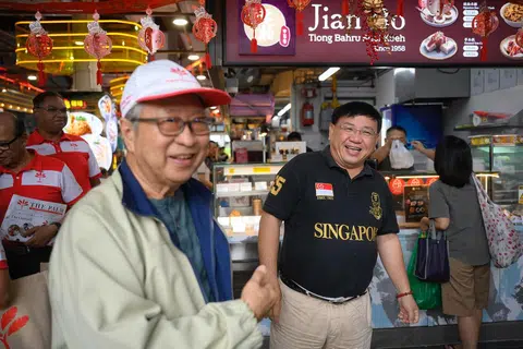 前进党主席陈清木医生（头戴白帽者）今年1月走访蔡厝港吉丰区时，巧遇民主联盟主席林睦荃（身穿黑色上衣者），你知道他们两人分别参加了几届选举吗？（海峡时报）