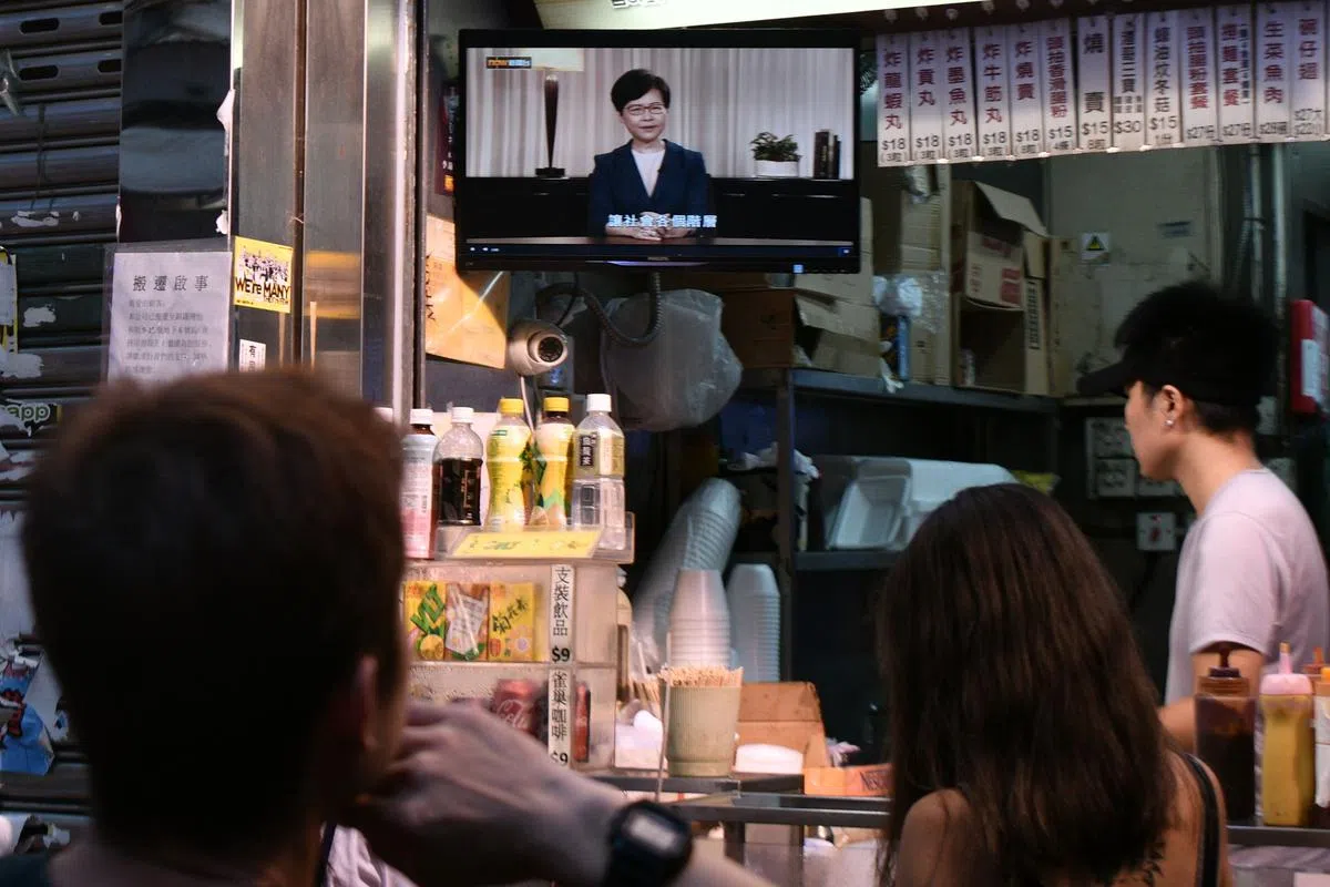  香港市民观看林郑月娥的电视谈话。（法新社） 