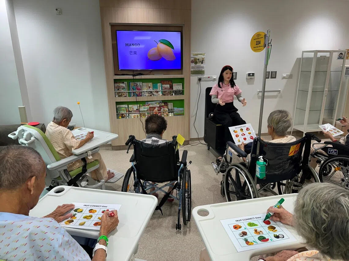 能听懂得讲多种本地语言和方言的人形机器人在给失智症患者“讲课”。