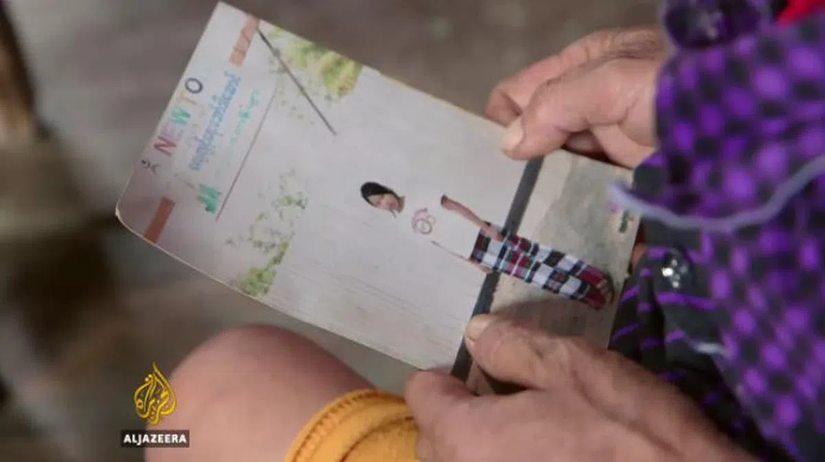  姐姐拿着磅艾赫多恩的遗照回忆。（半岛电视台） 