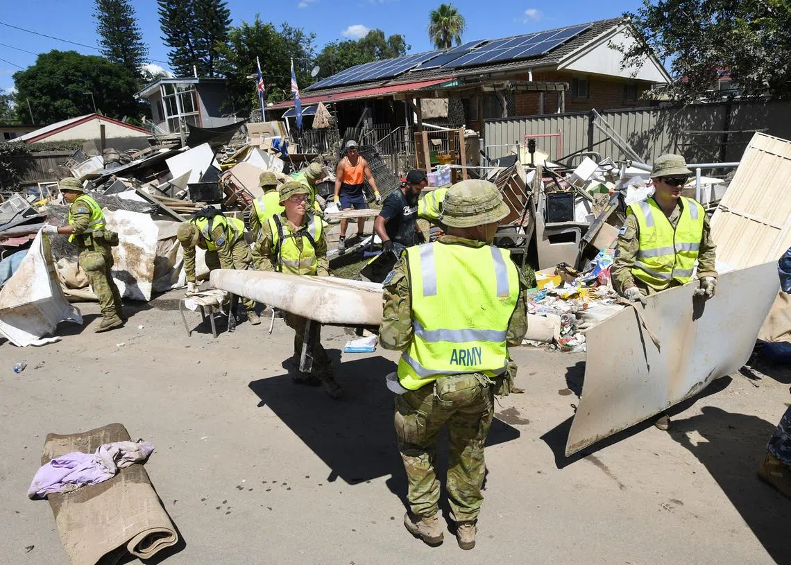 新南威尔士州水灾发生后现场一片狼藉，澳洲出动军人到灾区帮助居民重建家园。（路透社）