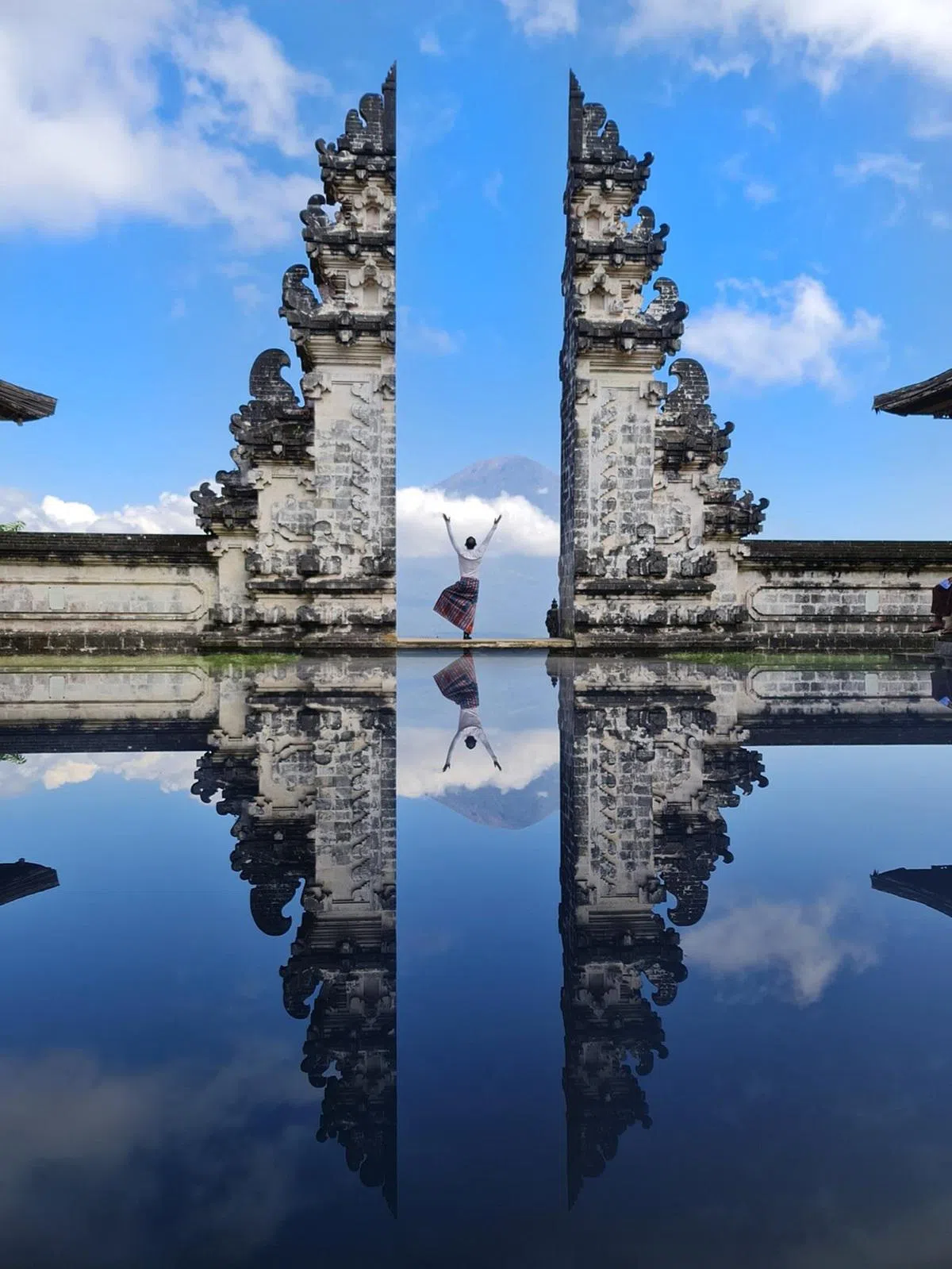 游客在连普扬寺庙（Lempuyang Temple）打卡，背景是阿贡火山（Mount Agung）。（tigerxmen）