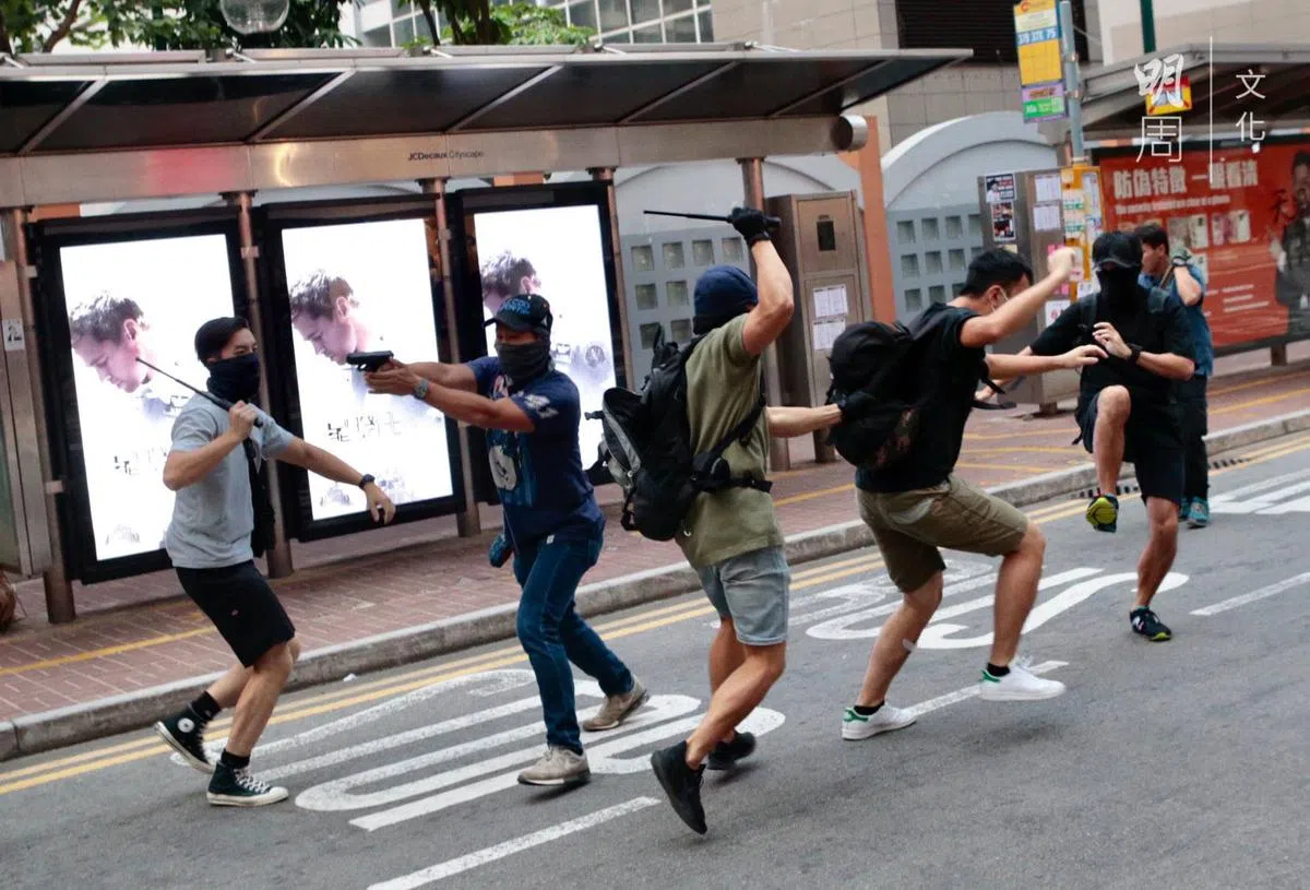  疑似卧底警员使用伸缩警棍攻击其他示威者。（明周文化） 