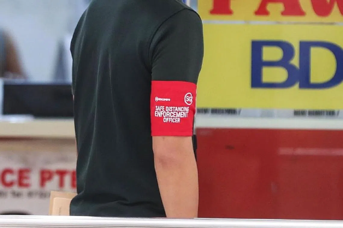 安全距离执法人员在执行任务时，都会佩戴有效的红色证件，或是SG Clean大使证件。另外，也可能会同时戴着红色臂章。（海峡时报）