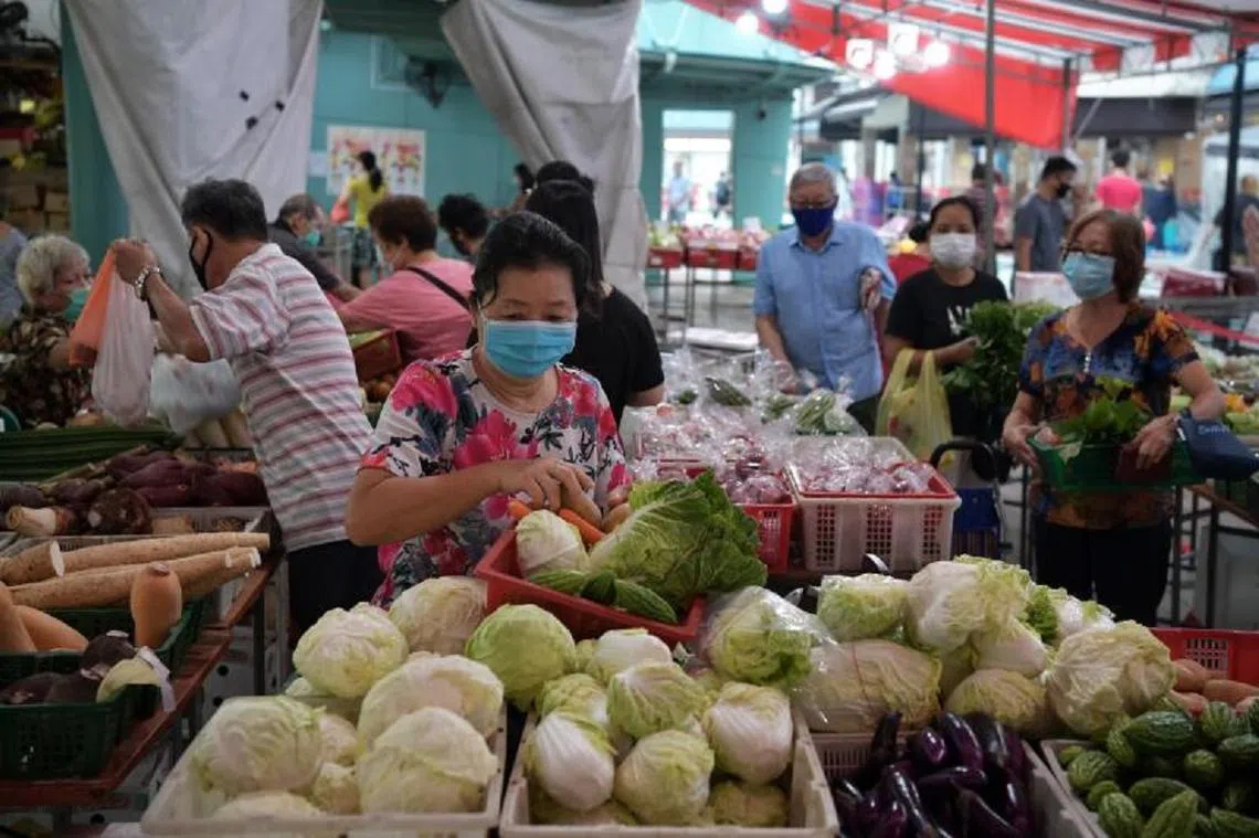 李显龙总理在本周二（4月21日）宣布病毒阻断措施延长多一个月后，上湿巴刹买菜的民众都比较自觉戴上口罩和遵守安全距离。（海峡时报）