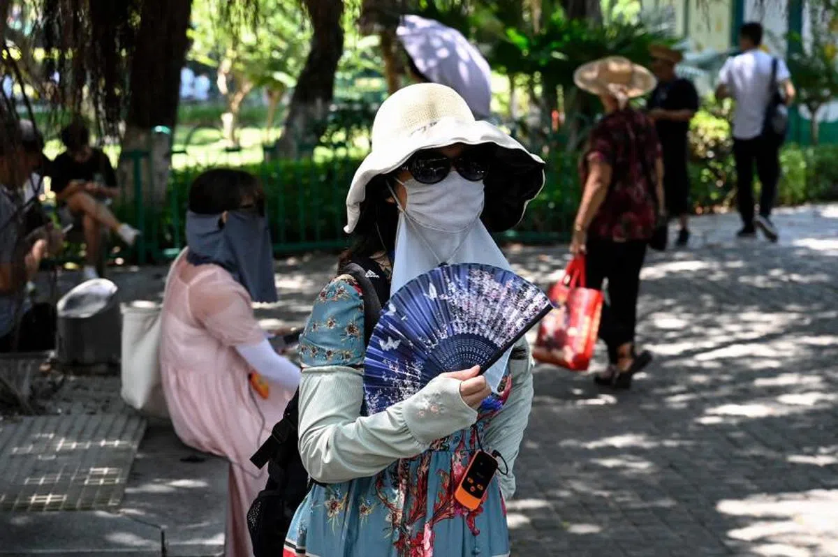 中国大妈们的独特降温避免晒黑的方式。（法新社）