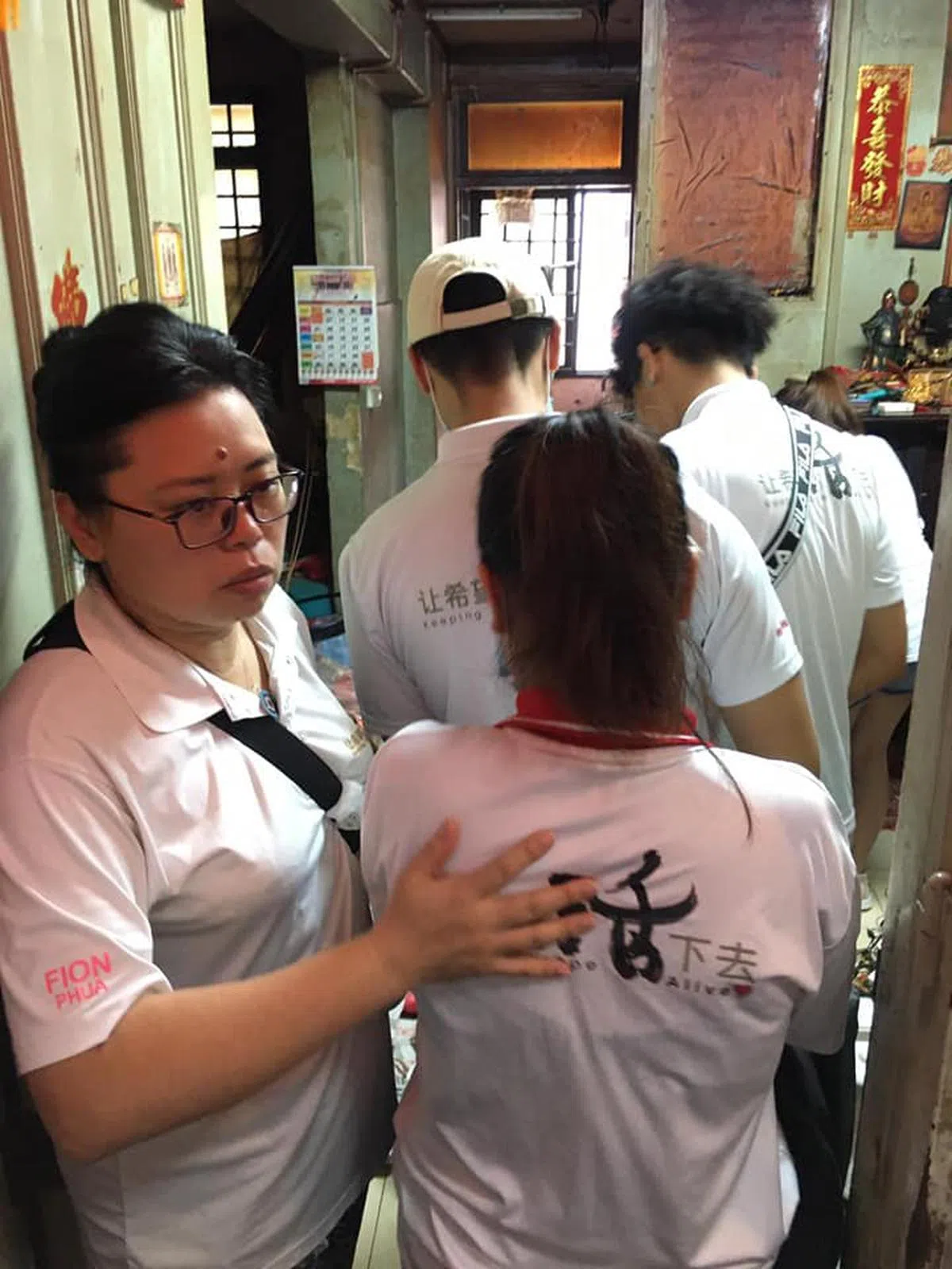  潘迎芬（左一）在“蟑螂王国”屋内指挥义工作战。（KHA面簿） 
