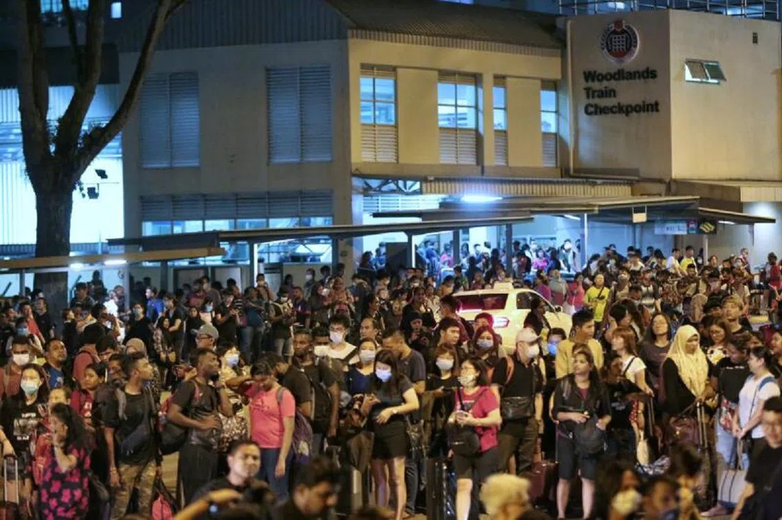 在18日马来西亚“锁国”前，成功抵达新加坡兀兰关卡的马国客工们。（新明日报）
