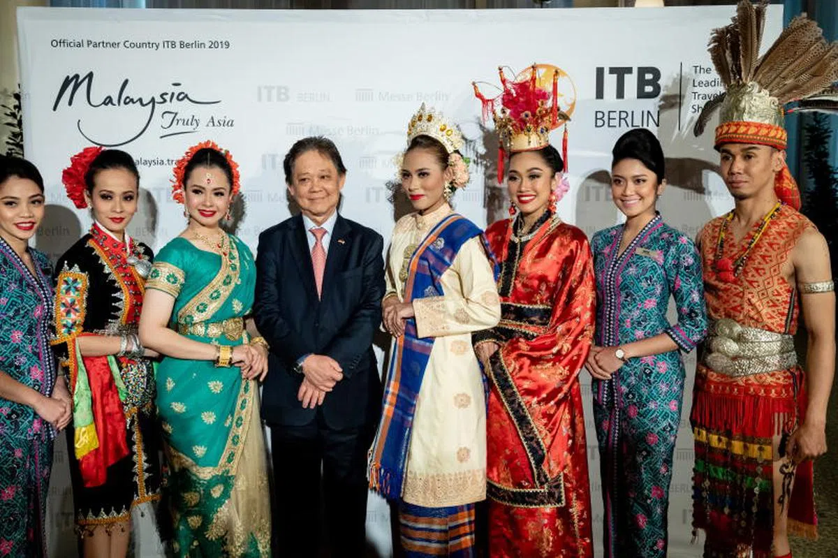  旅游、艺术及文化部长莫哈末丁哥达比（左四）在德国宣传及促销马来西亚旅游项目时与穿着马国民族服装的代表团成员合照。（欧新社） 