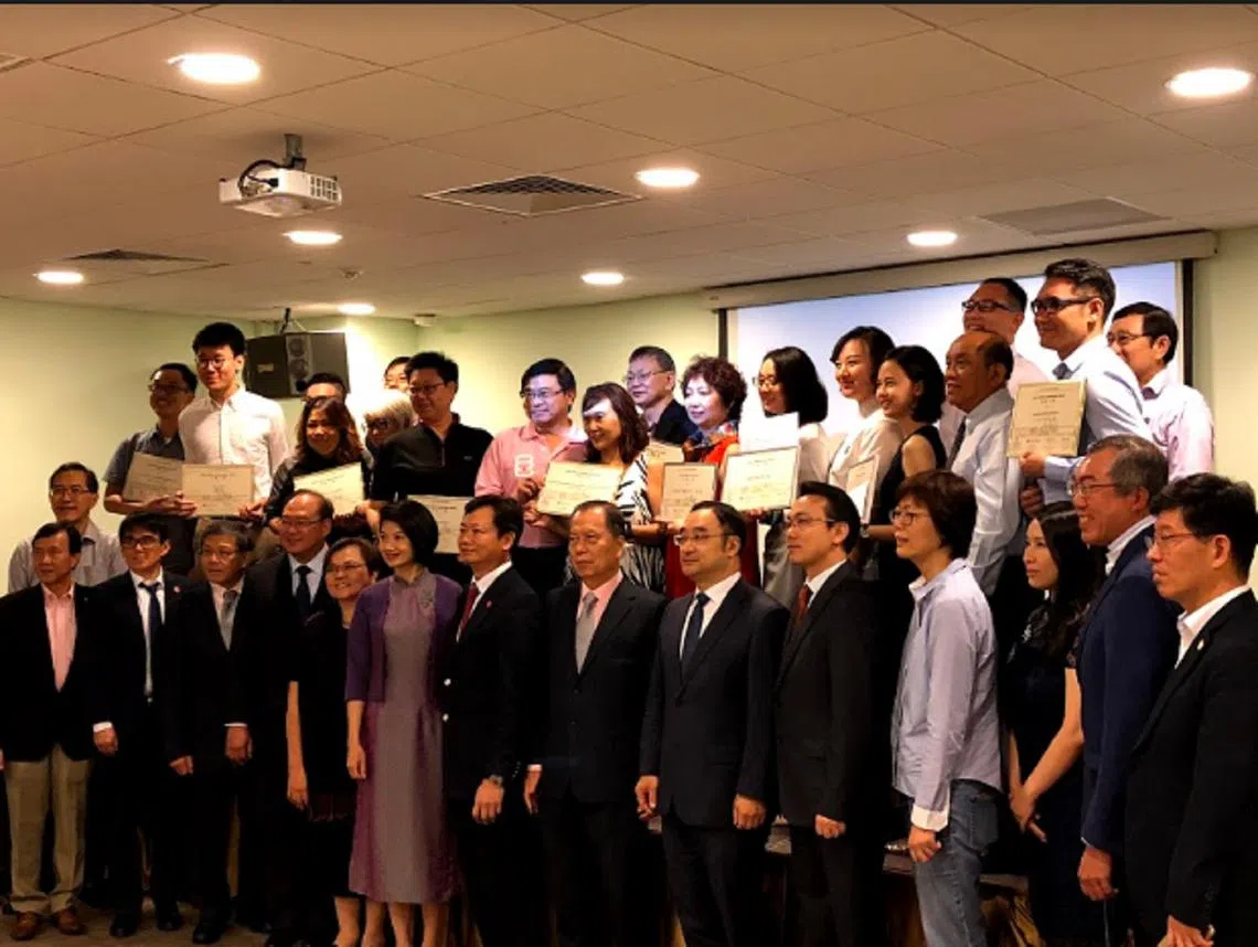 社会公益日活动的13组获奖团队代表（第二排）与前排的福建会馆、潮州八邑会馆、九龙会、江苏会代表、评审团以及主宾内政部兼国家发展部高级政务次长孙雪玲（前排左六）一起合照。（张丽苹摄）