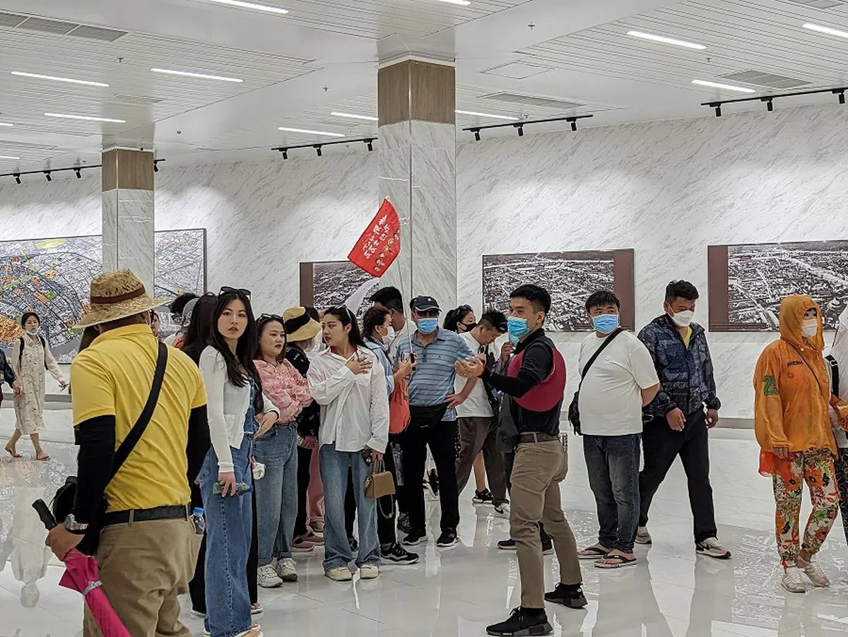 中国旅行团团员在泰国曼谷大皇宫地下道集合。（海峡时报）