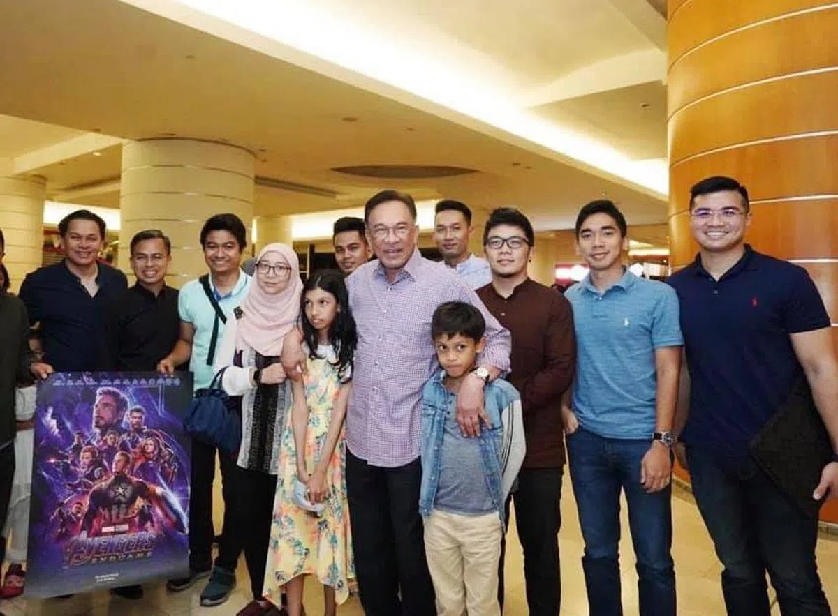 声称是性爱片男主角之一的哈兹阿兹（Haziq Aziz）（右一）和和安华（中）、安华家人及一些公正党领袖一同观赏电影后的大合照。（取自哈兹阿兹面簿） 