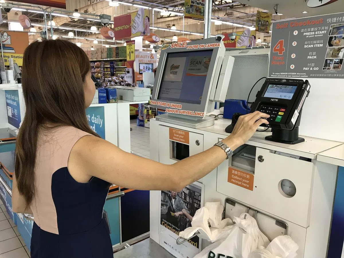  在一家大型超市的自助结账台，顾客正在使用统一付款终端机付款。11月1日起，公众在net、QR、net FlashPay、信贷和借记卡支付的基础上，使用微信支付购买。（海峡时报） 