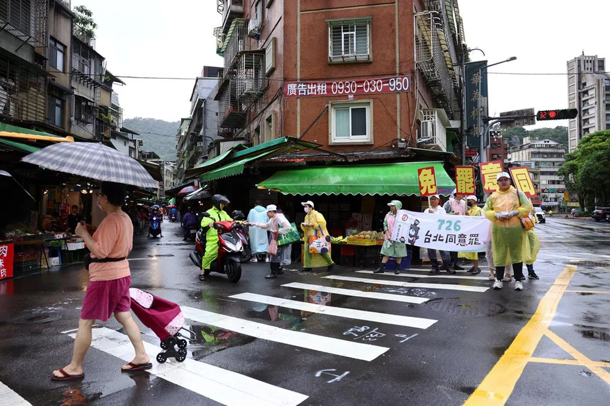 7月25日，大罢免支持者在台北街头举起布条、口号争取民众支持。（路透社）
