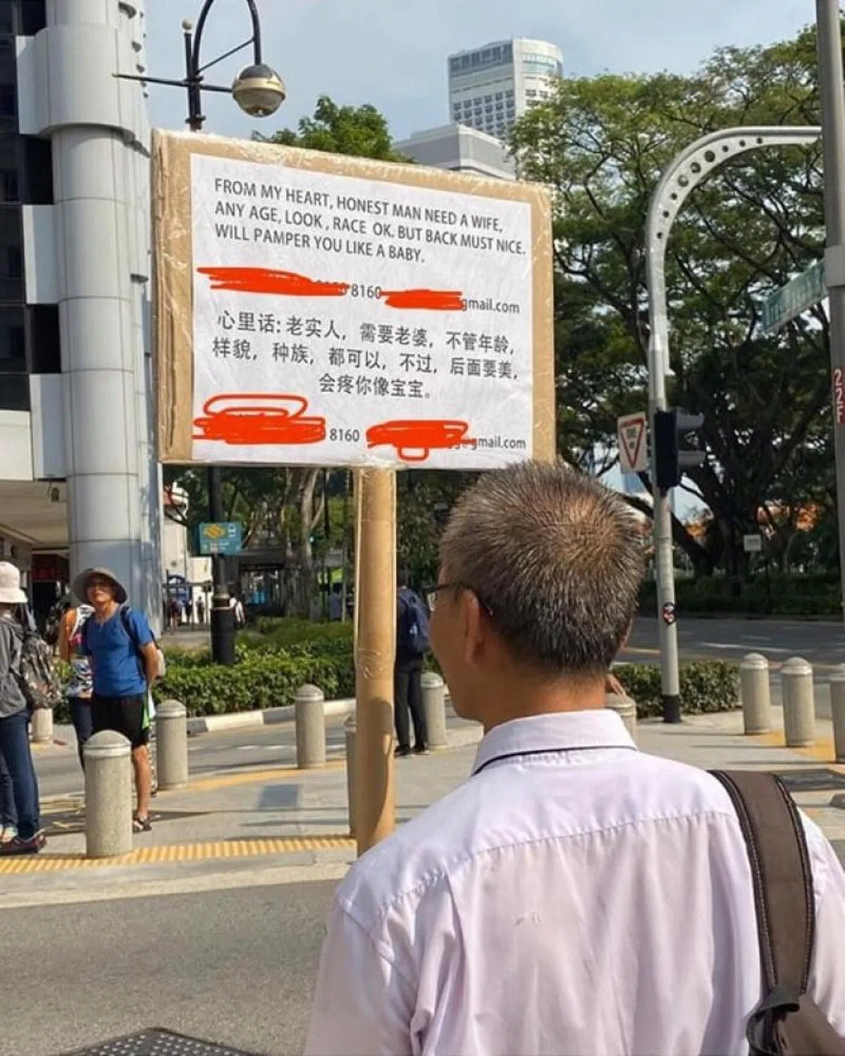  阿源被网民拍到举着牌子在来福士城附近边走边寻找爱。（互联网） 