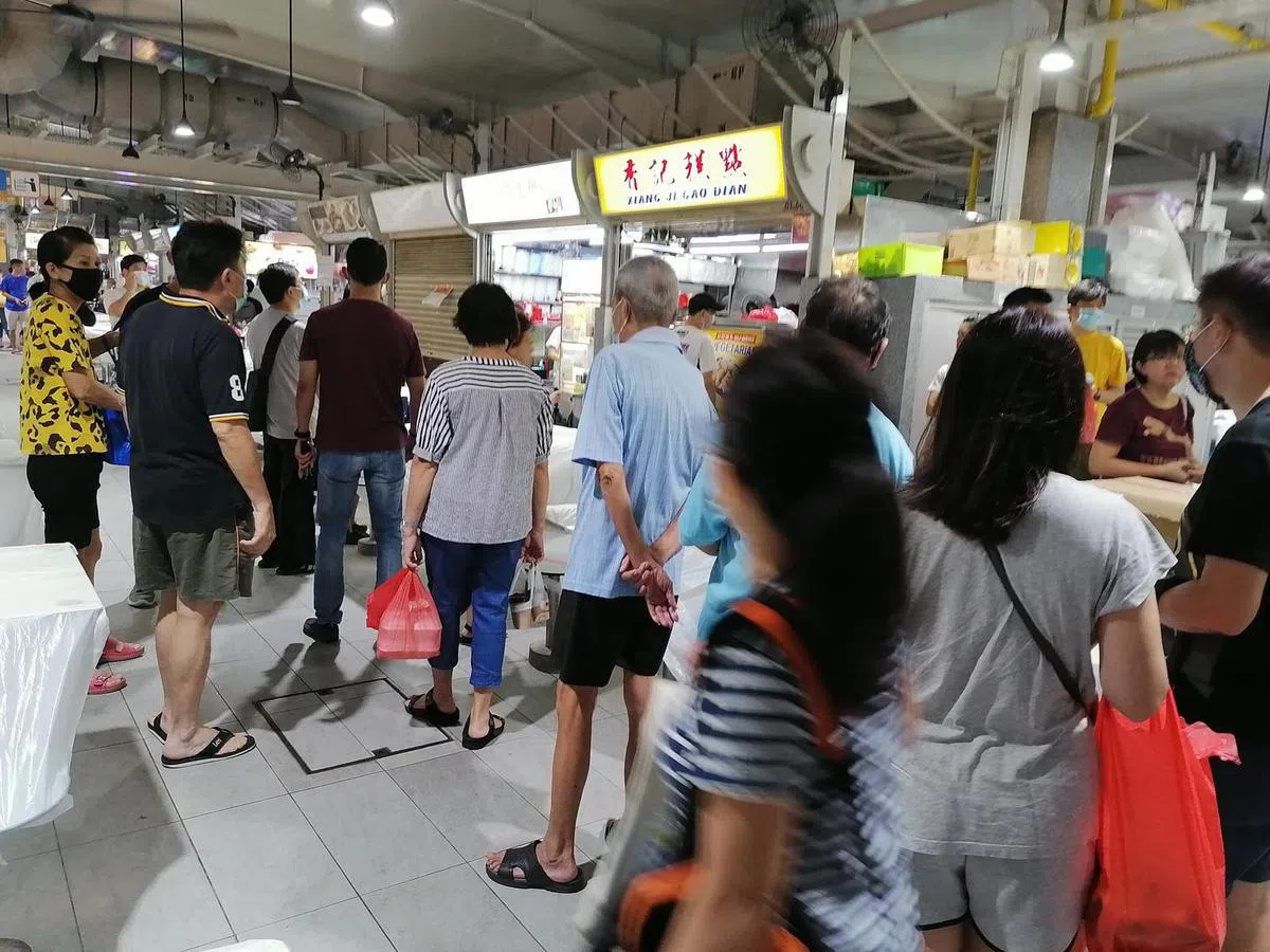  人们排队打包时，并没有刻意遵守安全距离规定。（何盈摄） 