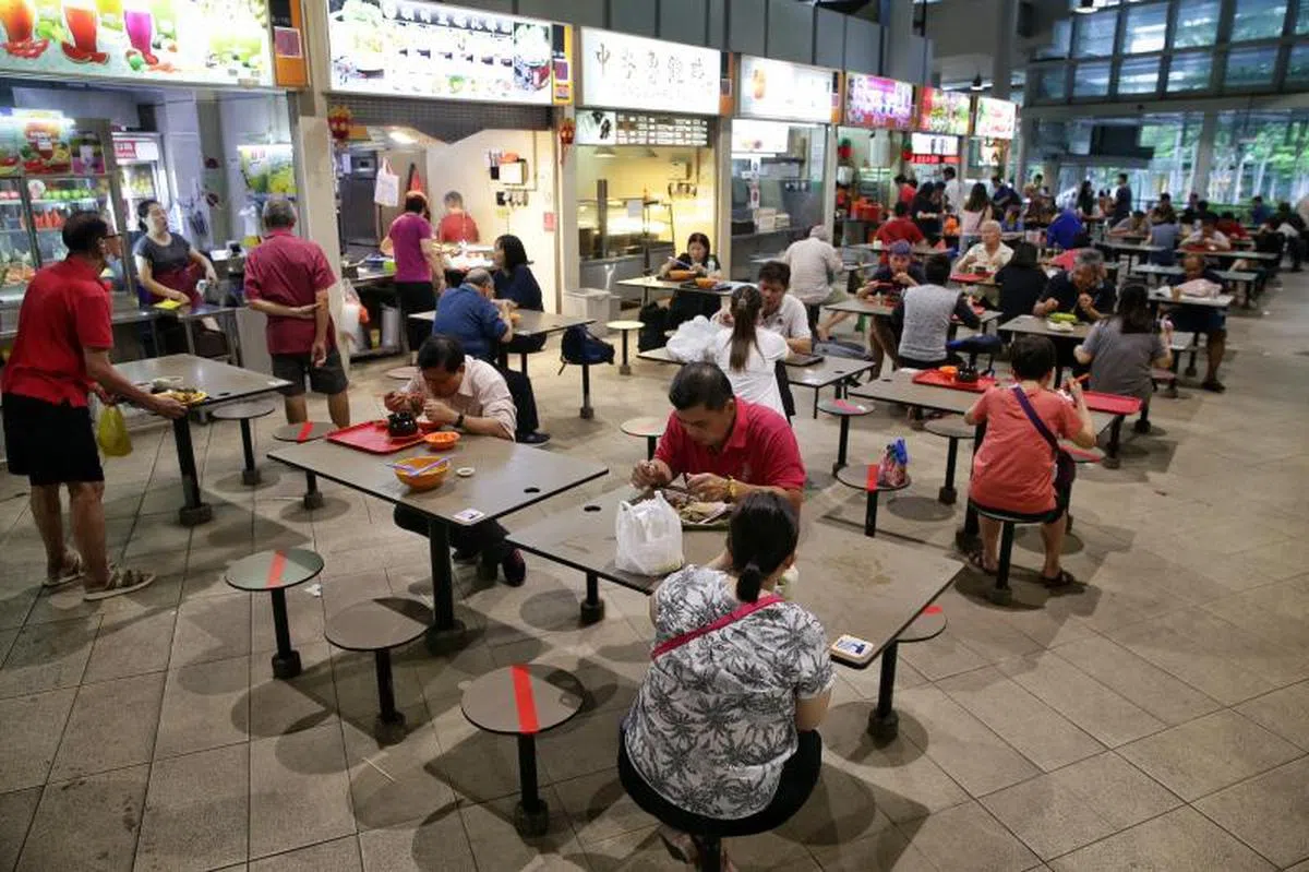  小贩中心部份椅子已被贴上红色胶带，提醒人们保持安全社交距离。（海峡时报） 