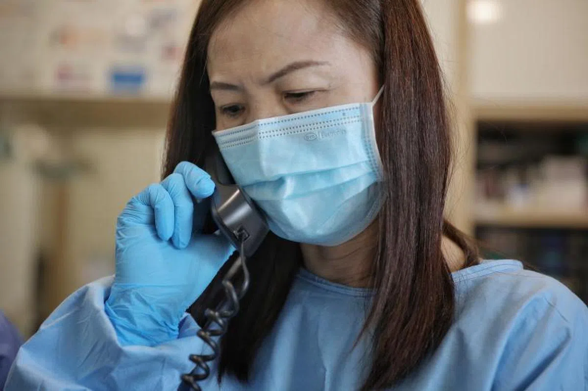 诊所的高级助理Sindy Chong正在接听一通咨询电话。（海峡时报）