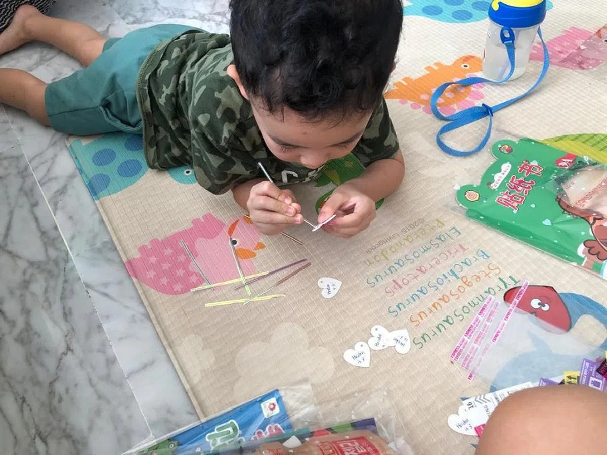 当时就快3岁的儿子负责把写有“他三岁了”的小心心绑在礼物上。（红蚂蚁摄）