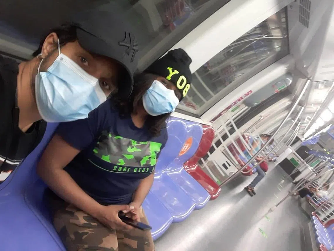 夫妻俩戴口罩体验乘坐本地地铁。（Brahim Casseem）