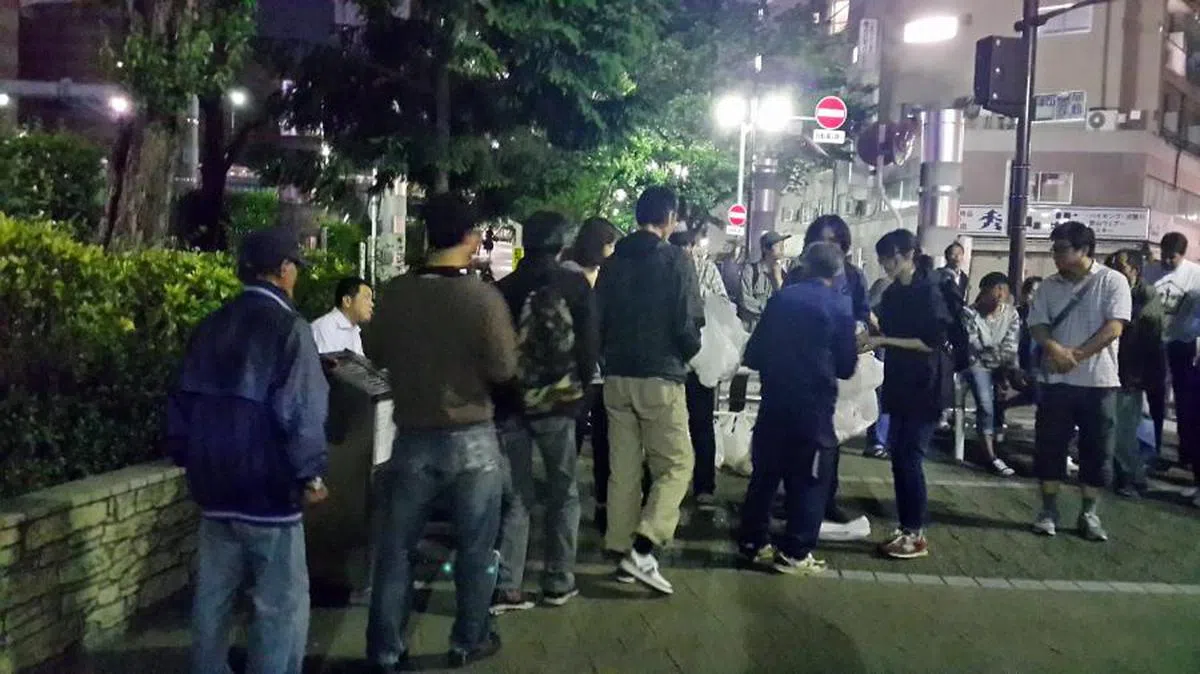 日本东京福利组织为街友免费派发食物。（海峡时报）