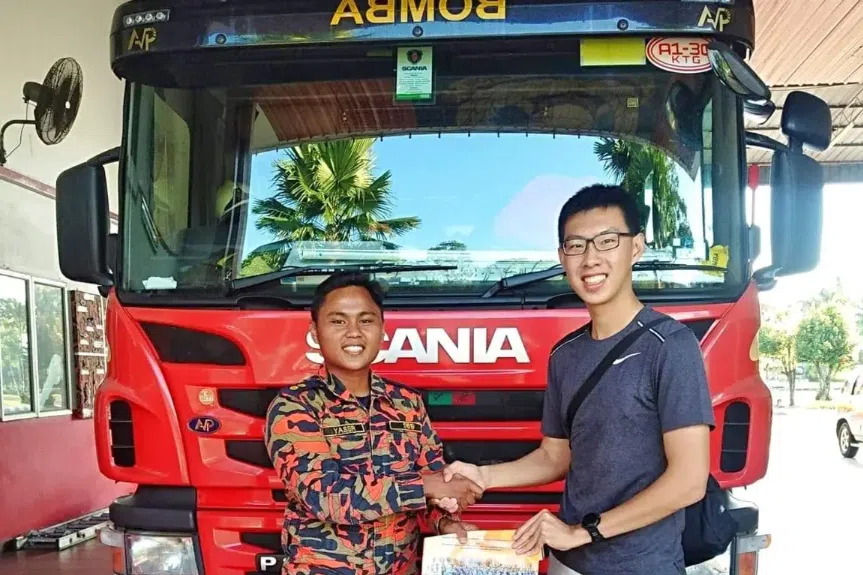 莫宏（右）与马来西亚消防员展开人生中首次消防T恤交换。