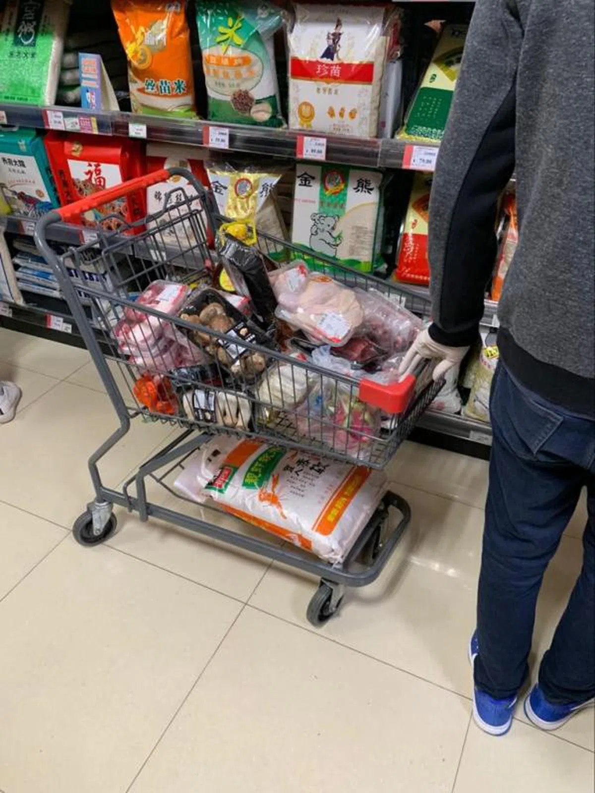  这位大哥戴着医用乳胶手套囤货。当下觉得他很夸张，后来广州疾控中心在患者家中门把上发现新冠病毒踪迹，顿时意识到：大哥很有先见之明啊。（卢凌之摄） 