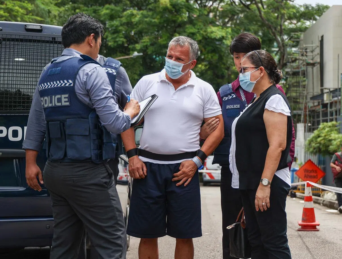 嫌犯加西亚（身穿白色有领汗衫者）在案发现场接受警方问话。（联合早报）