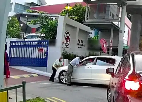 一名宾利私家车司机不顾校方保安及工作人员的阻拦，硬闯卍慈学校，甚至撞上保安腿部。（视频截图）