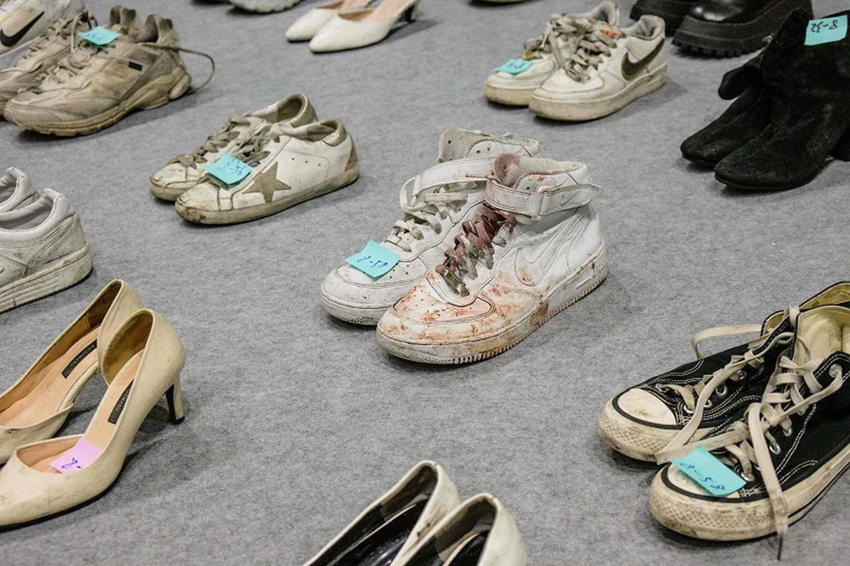 地面上摆放着一排排的鞋子，等待家属来招领，但已无法物归原主。（法新社）