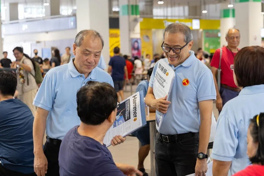 工人党前党魁刘程强（左）与现任后港区议员陈立峰一同与民众交流。