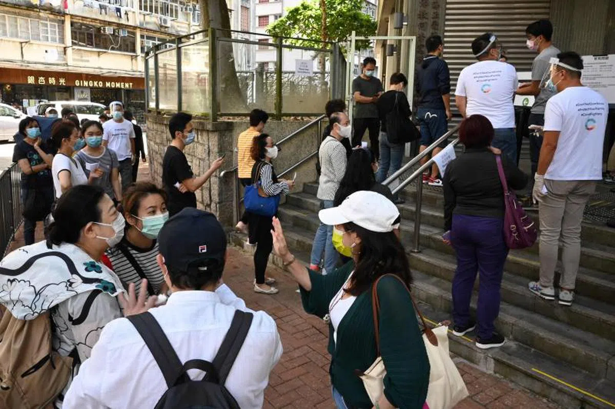  香港疫情日趋严峻，图为当地民众在一家检测中心外等候。（法新社） 