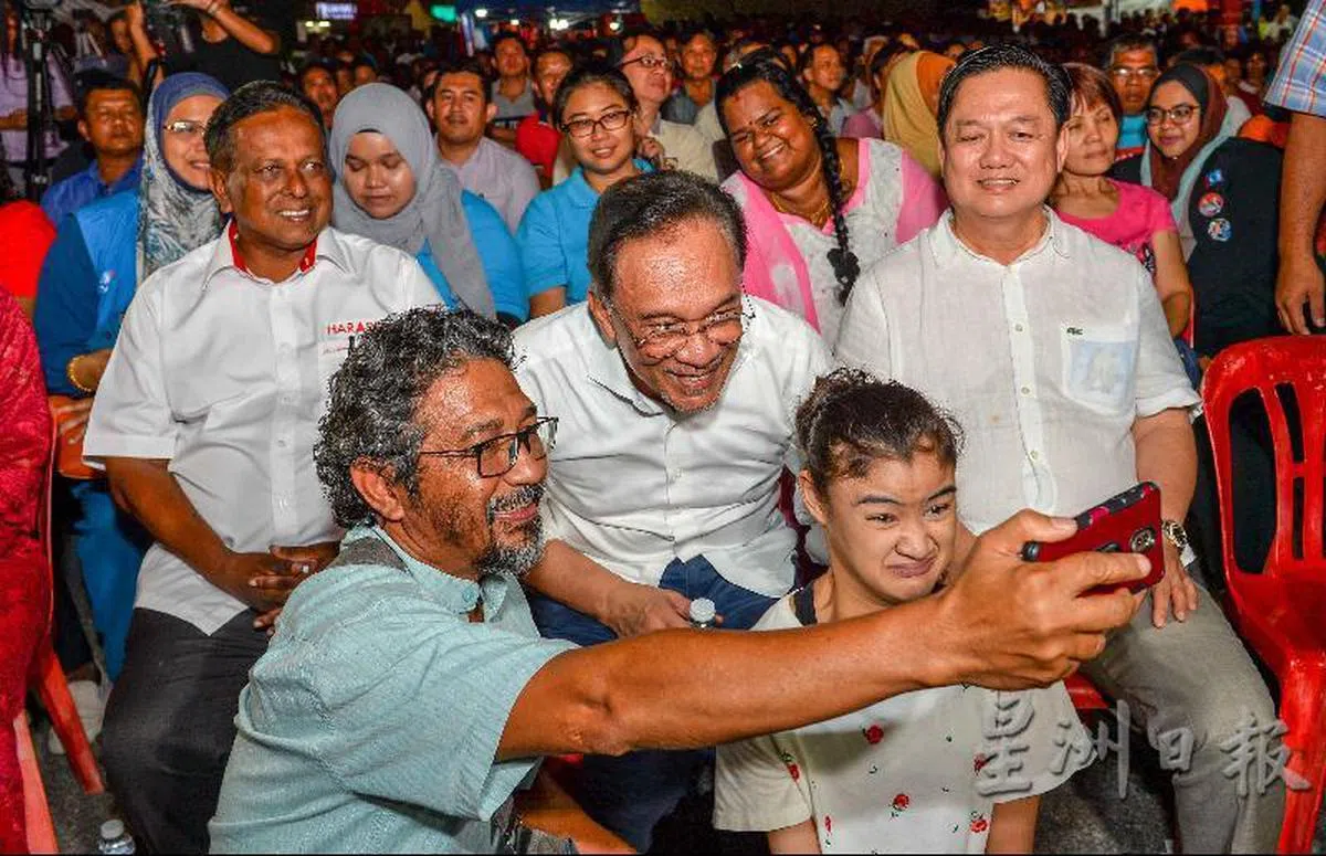  安华在晏斗选区连赶数场政治讲座略显疲态，依然展现亲民态度与选民自拍。（星洲日报） 