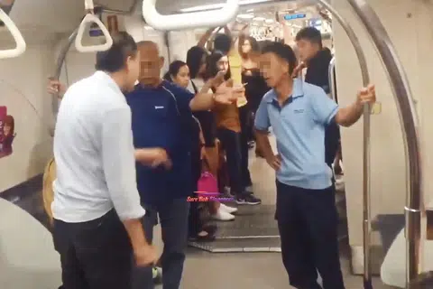（左一）背对镜头的新加坡大叔与（右一）身穿浅蓝色上衣的中国大叔在地铁上开骂，另一名新加坡大叔（深蓝色上衣者）从中劝架。（视频截图）