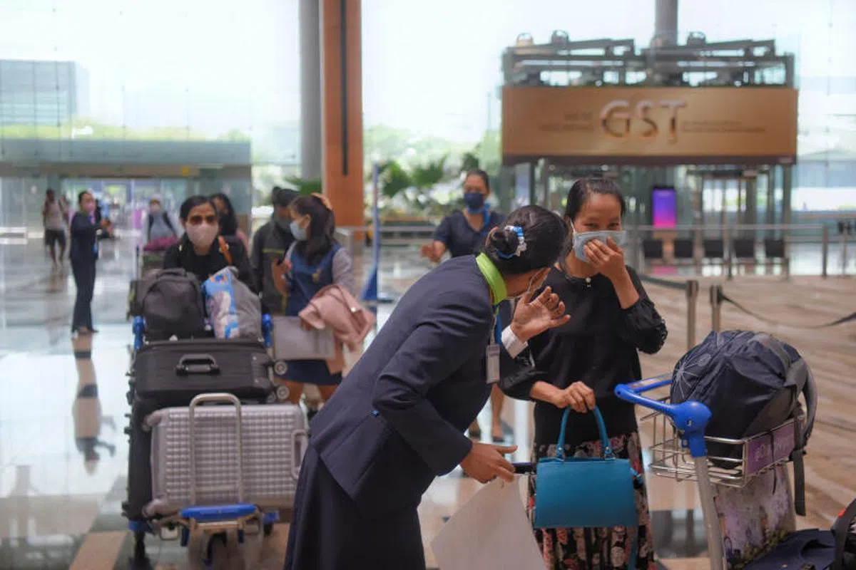 机组人员指示乘客戴好口罩。（海峡时报）