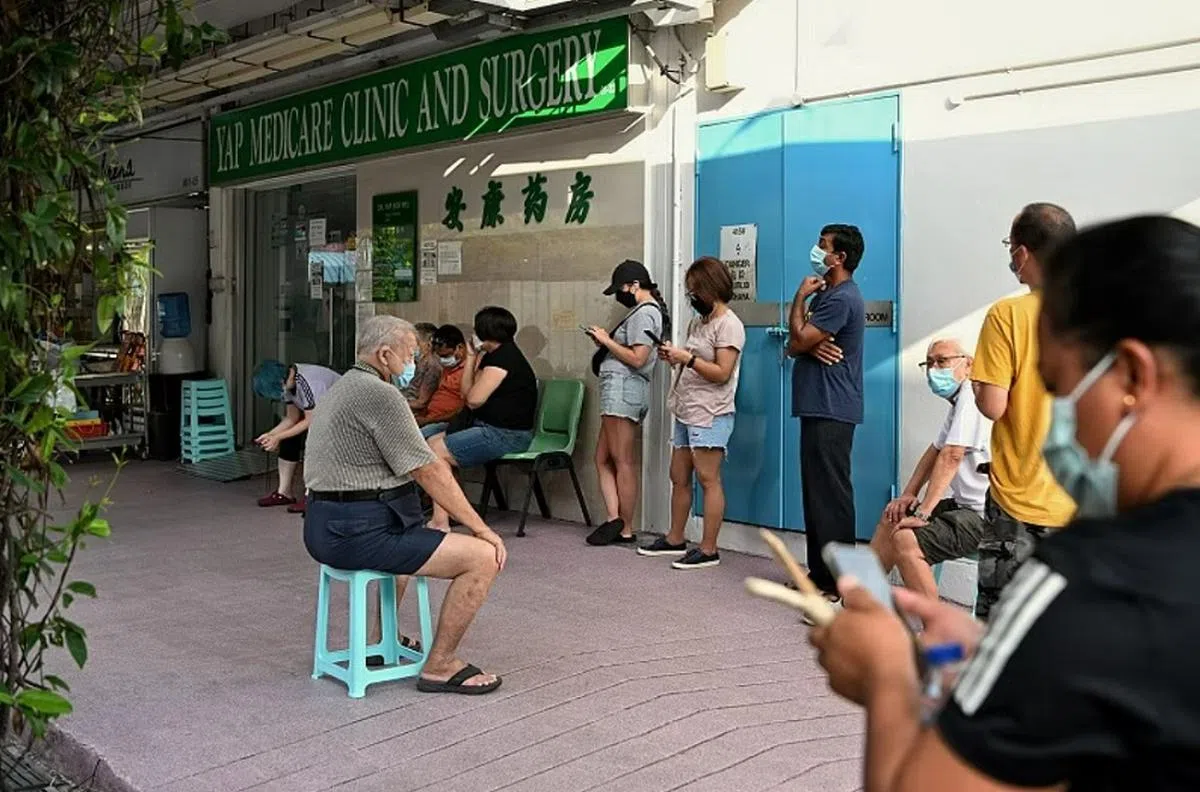 每到年底流感季节，诊所外一定大排长龙。（海峡时报）