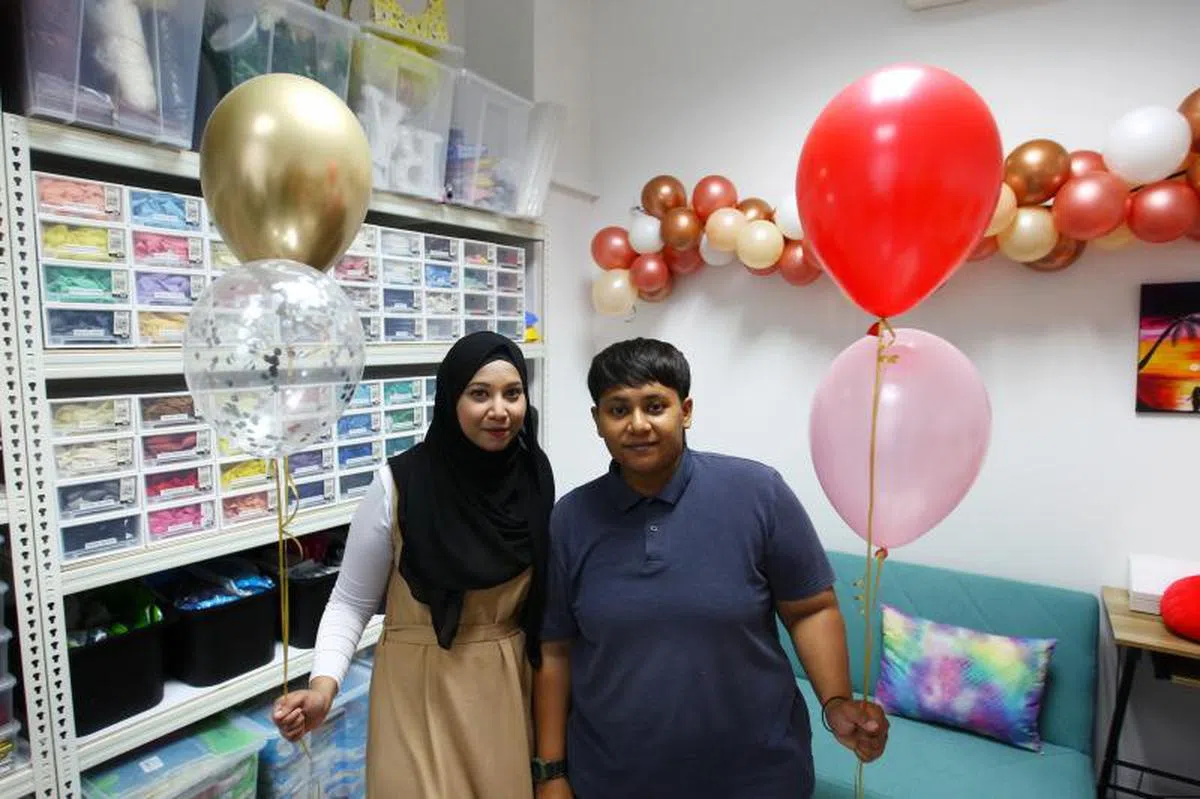 Nabeelah（左）与表姐Siti一同经营上门布置派对的居家生意。（海峡时报）