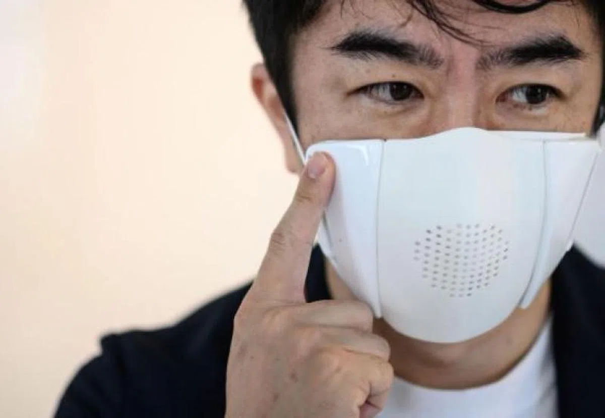  小野泰助展示如何装置智能口罩C-Face，须覆盖在一般口罩上。（法新社） 