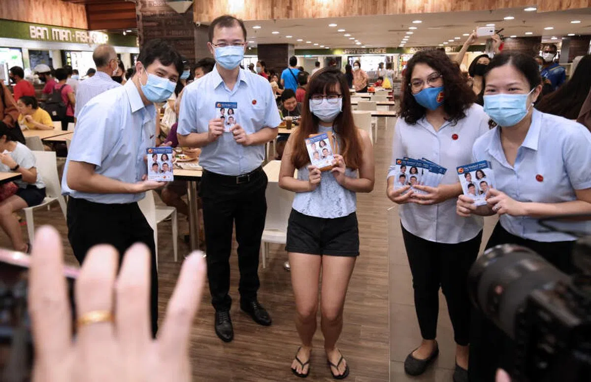  2020年大选竞选期间，工人党盛港集选区竞选团队于7月7日走访选区，到鲤河大厦派发竞选传单，年轻居民纷纷邀他们拍照。工人党候选人林志蔚（左一）、蔡庆威（左二）、辣玉莎（右二）与何廷儒（右一）与年轻居民合影。（联合早报） 