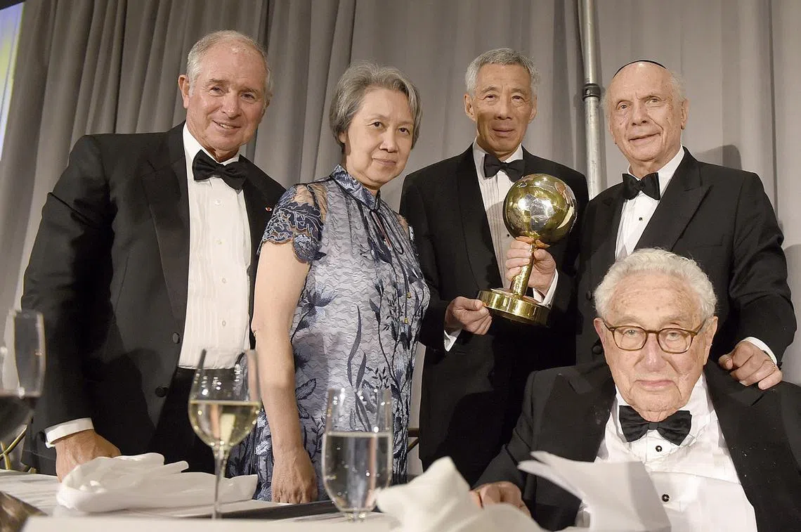 李显龙总理（后排右二）在第54届良知基金会颁奖晚宴上，获颁世界领导人奖，由美国前国务卿基辛格（前排）宣读授勋赞词。后排右起为良知基金会主席施奈尔、总理夫人何晶，以及晚宴主席之一、黑石集团总裁苏世民。 （联合早报）