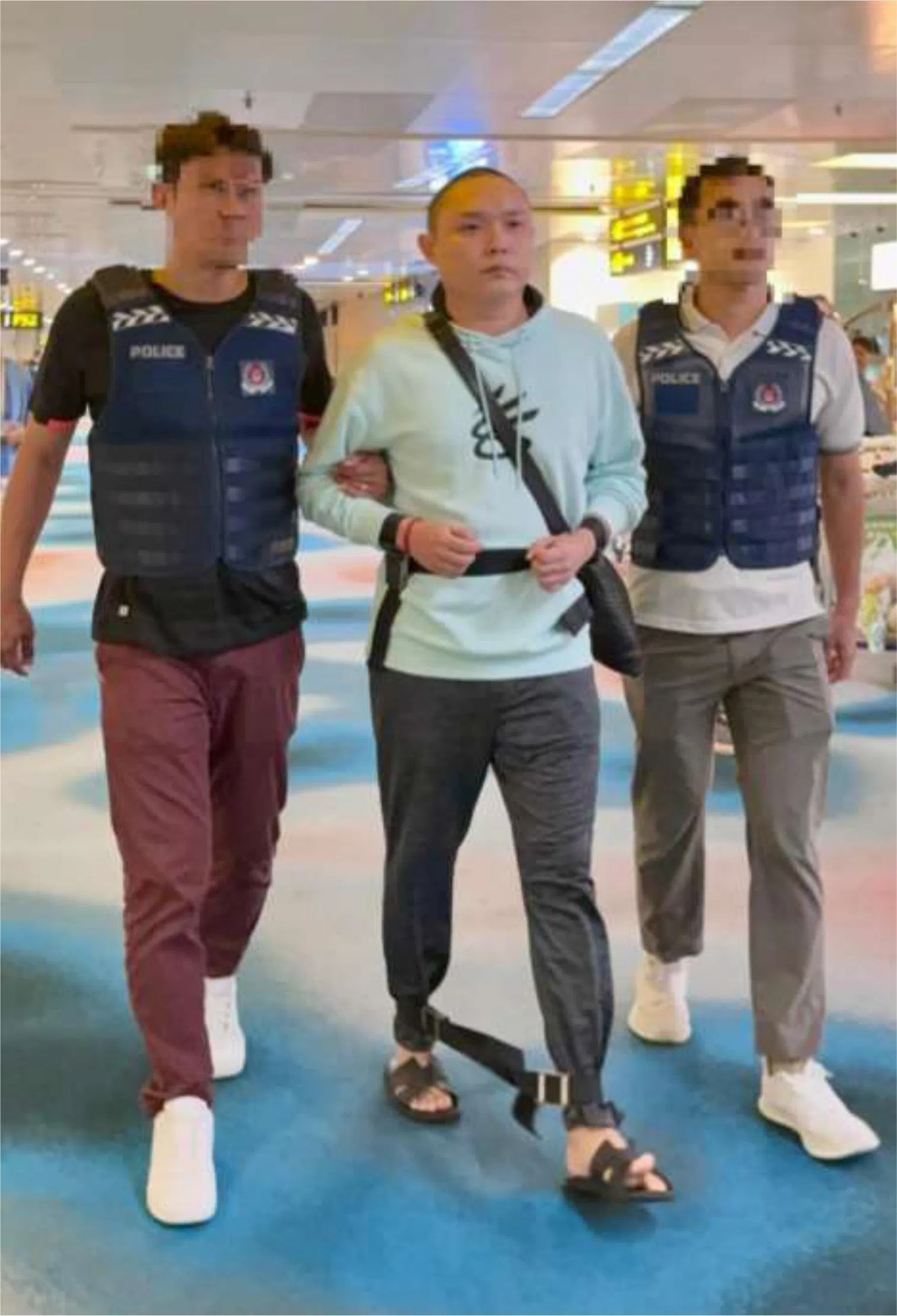 新加坡籍被告李健豪（中），2025年12月5日在国家法院被控两项抵触《有组织罪案法令》的罪状。