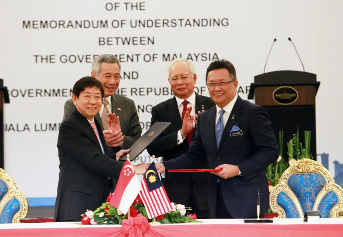  李显龙总理（后排左起）与马国时任首相纳吉在2016年7月19日一同见证由基础建设统筹部长兼交通部长许文远（前排左起），以及马国掌管经济策划局的首相署部长阿都拉曼达兰签署新隆高铁谅解备忘录。（联合早报） 